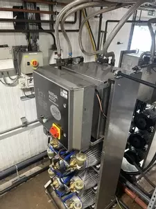 Rear view of custom stainless steel replacement tank installed on a Nilfisk Delta Booster multi-pump pressure washer system.
